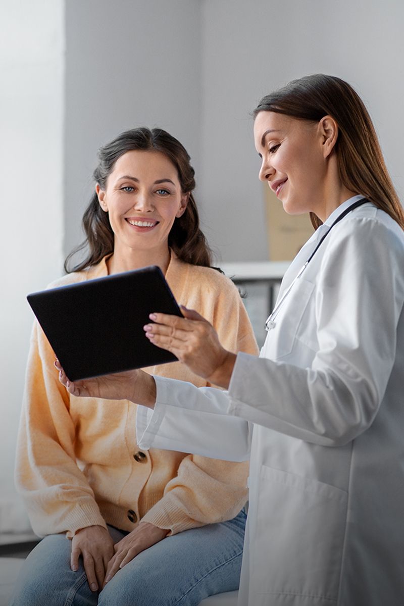 Doctor consulting with patient using digital tablet